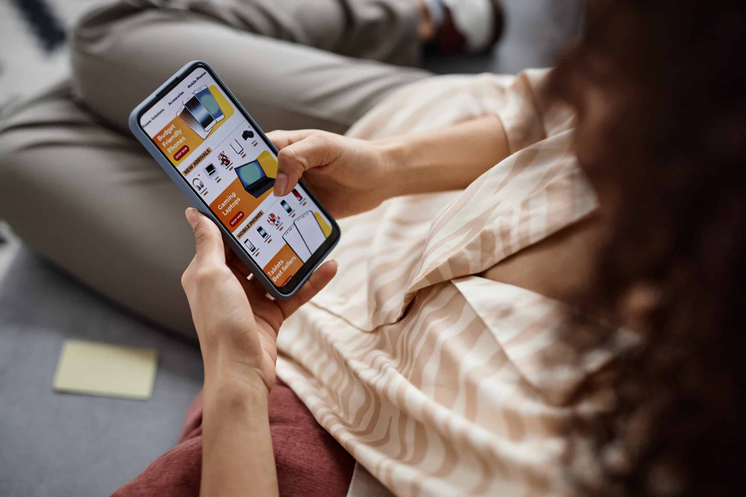 Woman shopping for electronics on a mobile phone app.